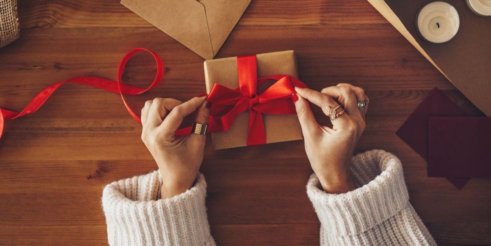 woman wrapping a christmas present royalty free image 1608157347