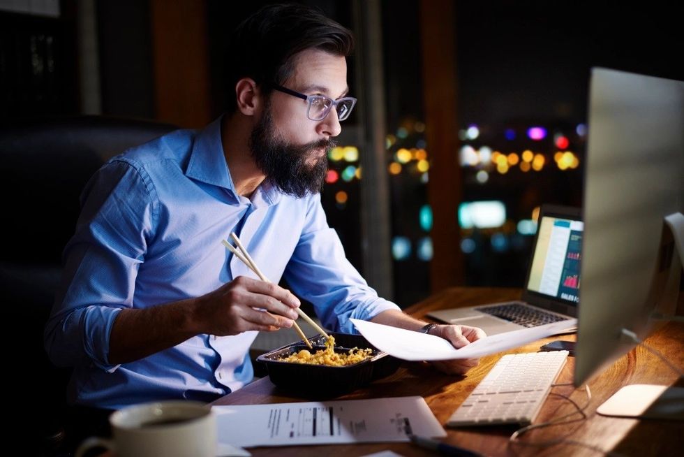 young businessman looking computer eating 586603554 1