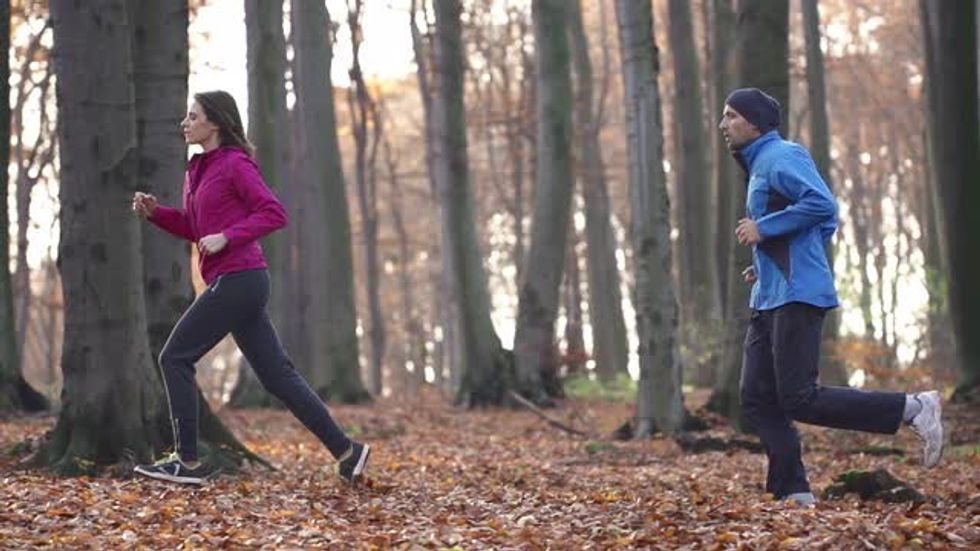 young couple jogging in autumn forest super slow motion shot at 240fps 4yviiuhge M0000