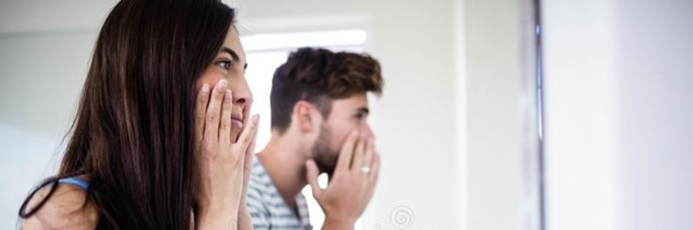 young couple looking themselves mirror bathroom 66159095