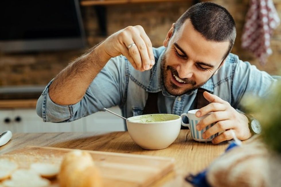 young happy man using salt while preparing food kitchen 637285 5754