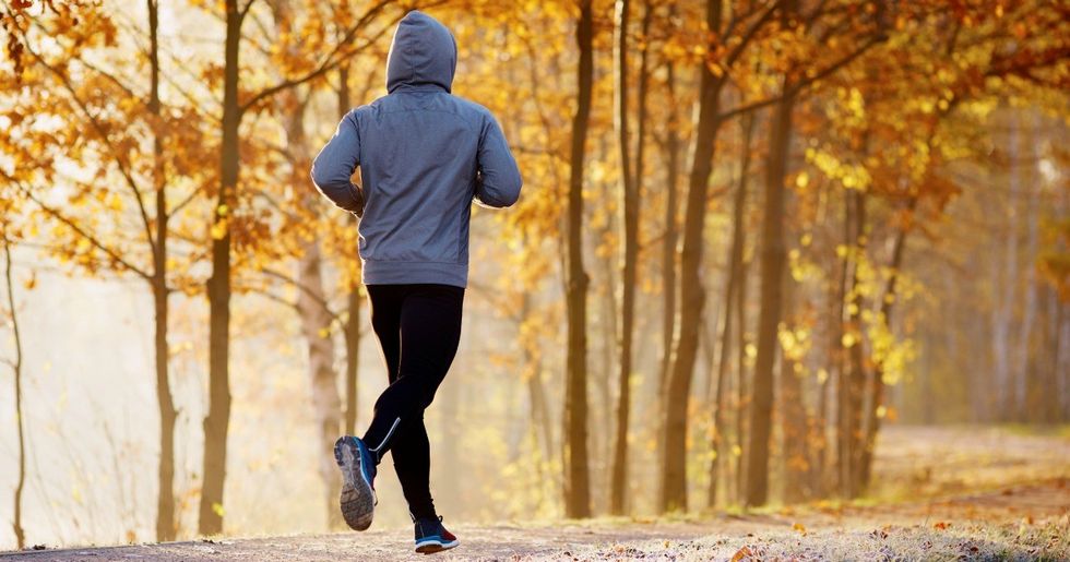 Young man running in the park during autumn morning