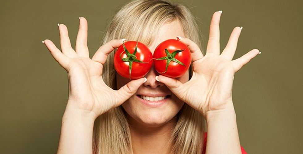 Young woman holding tomatoes
