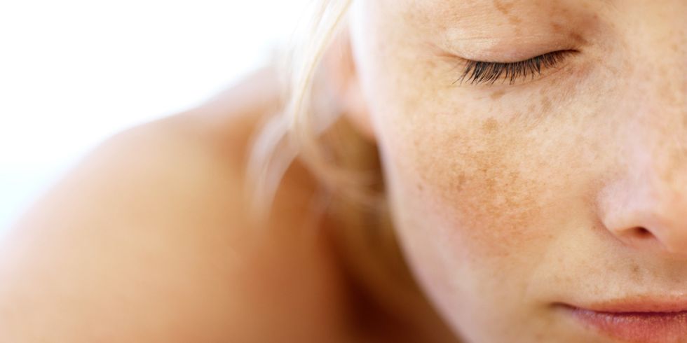 young woman lying on massage table close up head shot closed eyes