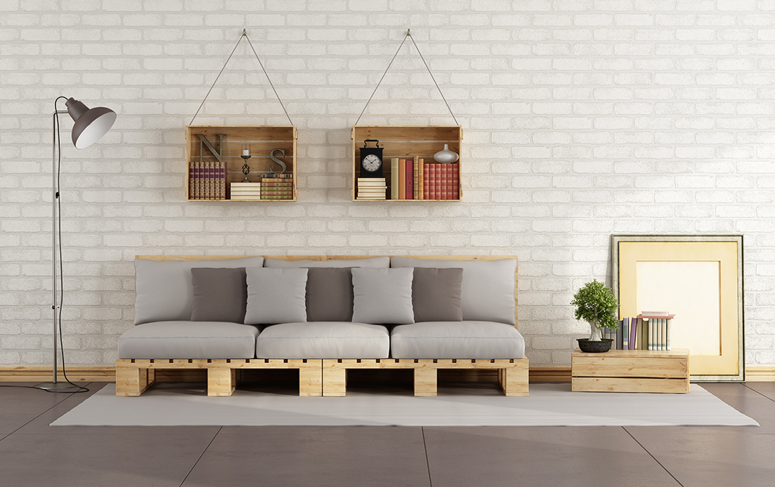 Living room with pallet sofa and wooden crate with books on brick wall - 3D Rendering