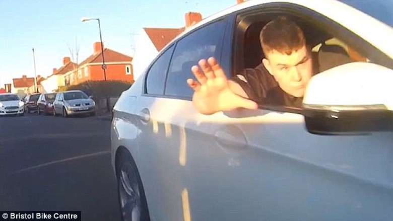 Momenti i frikshëm: Zgjat dorën nga BMW-ja për të rrëzuar motoçiklistin (Video)