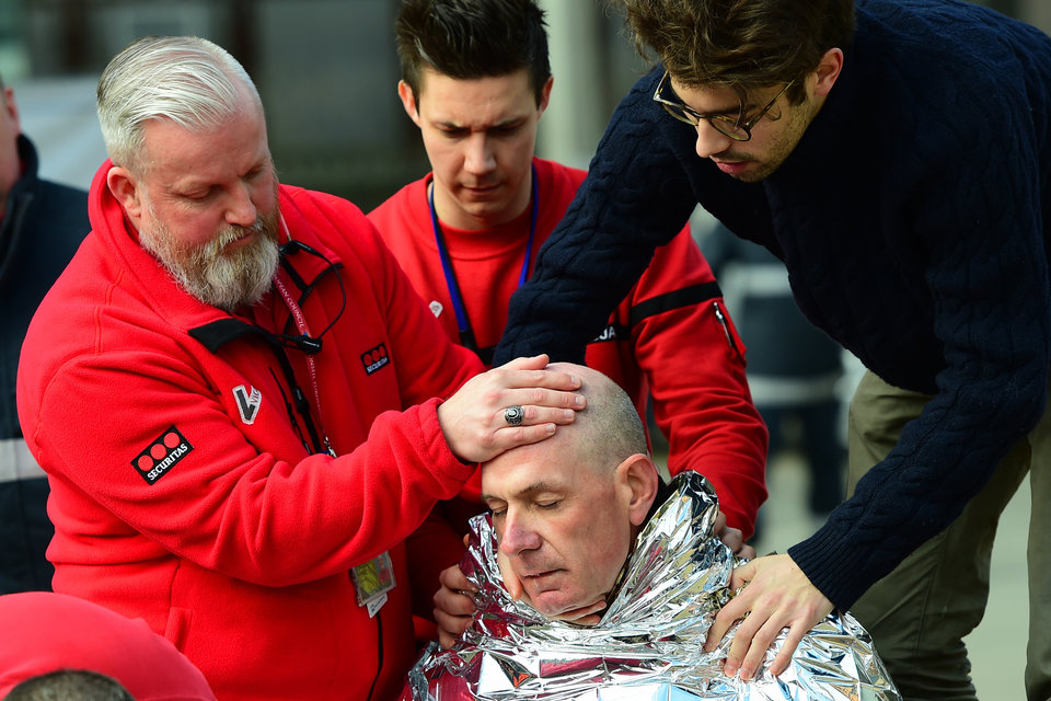 A victim receives first aid by rescuers, on March 22, 2016 near Maalbeek metro station in Brussels, after a blast at this station near the EU institutions caused deaths and injuries.  AFP PHOTO / EMMANUEL DUNAND / AFP / EMMANUEL DUNAND        (Photo credit should read EMMANUEL DUNAND/AFP/Getty Images)