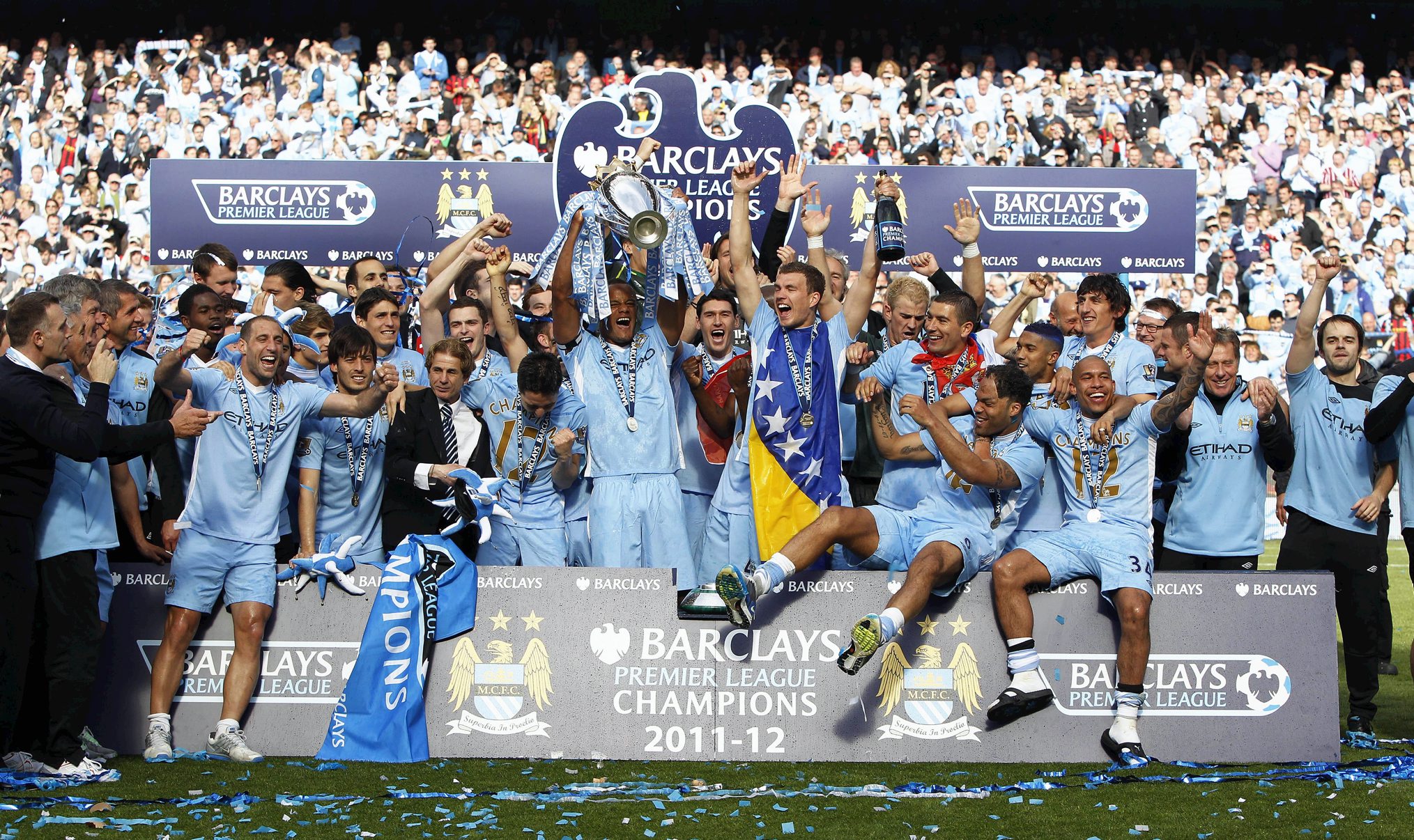 Manchester City players celebrate with the trophy after winning the Premier League during the Barclays Premier League match at the Etihad Stadium, Manchester. PRESS ASSOCIATION Photo. Picture date: Sunday May 13, 2012. See PA story SOCCER Man City. Photo credit should read: Peter Byrne/PA Wire. RESTRICTIONS: Editorial use only. Maximum 45 images during a match. No video emulation or promotion as 'live'. No use in games, competitions, merchandise, betting or single club/player services. No use with unofficial audio, video, data, fixtures or club/league logos.