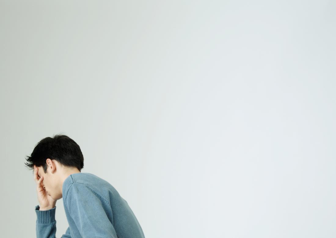 Young man covering face with hand