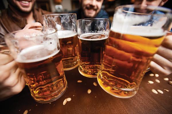 Four men toasting with fresh beer