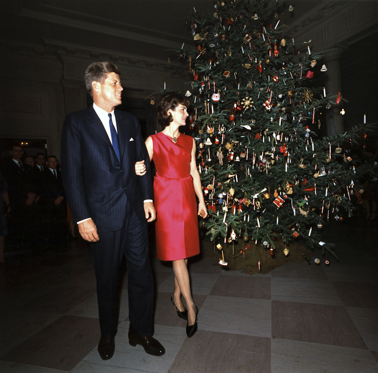 KN-C25669 12 December 1962 President and Mrs. Kennedy pose in front of the White House Christmas Tree during the Staff Christmas Reception. White House, Entrance Hall. Photograph by Robert Knudsen, White House, in the John F. Kennedy Presidential Library and Museum, Boston.