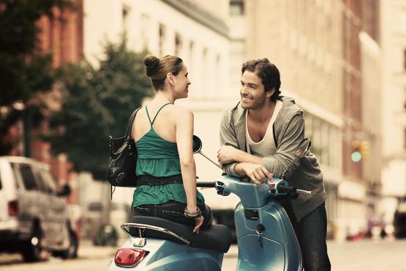 Woman-on-moped-talking-to-man-in-street