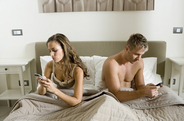 Young couple using smart phones in bed --- Image by © Steve Sparrow/cultura/Corbis