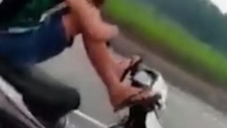 Adoleshenti drejton motoçikletën me këmbë, teksa flet në telefon (Video)