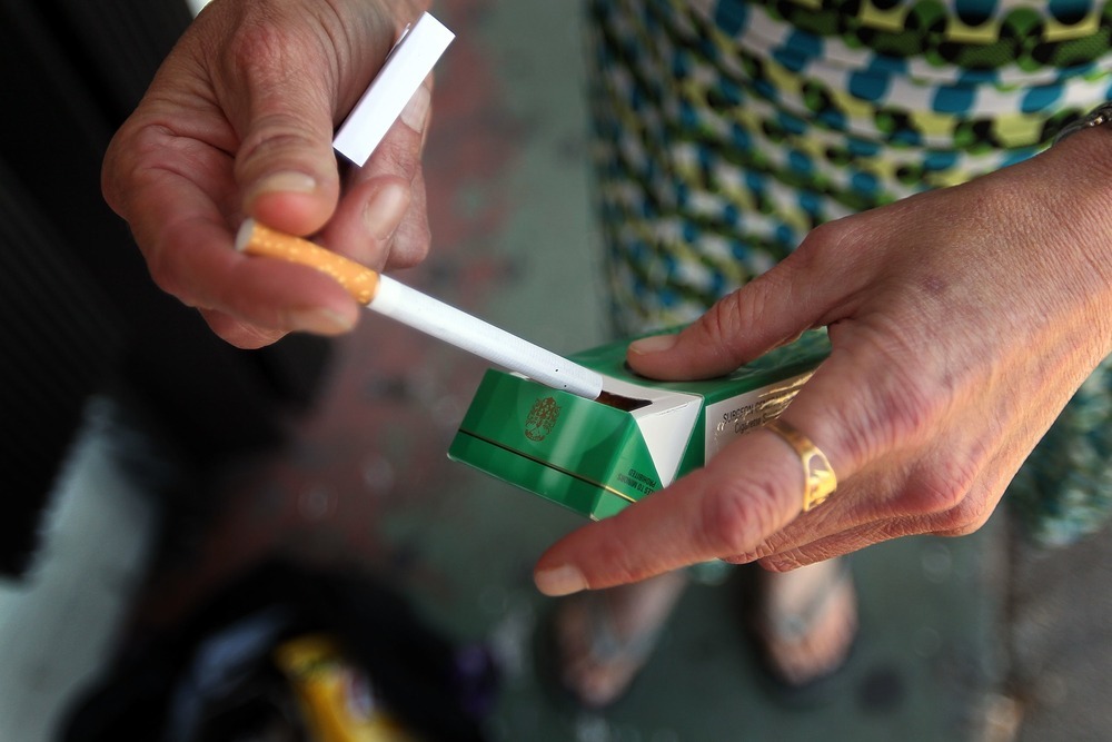 MIAMI - MARCH 30:  Brenda Wisehart smokes a menthol cigarette in front of a Quick Stop store on March 30, 2010 in Miami, Florida.  Today in Washington, DC a public hearing began before a committee of outside experts that advises the Food and Drug Administration as they weigh the evidence of menthol's impact on smokers' use and health. The FDA could eventually ban or phase out the menthol cigarettes that some experts say can be more enticing and possibly addicting than regular cigarettes.  (Photo by Joe Raedle/Getty Images)