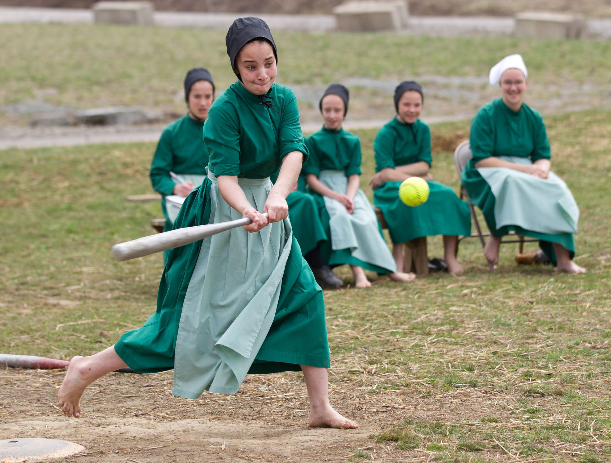 Amish girls play softball after class during an end of the school year celebration on Tuesday, April 9, 2013 in Bergholz, Ohio. The celebration was also part of a farewell picnic for those sentenced in the hair and beard cutting scandal earlier in the year. (AP Photo/Scott R. Galvin)