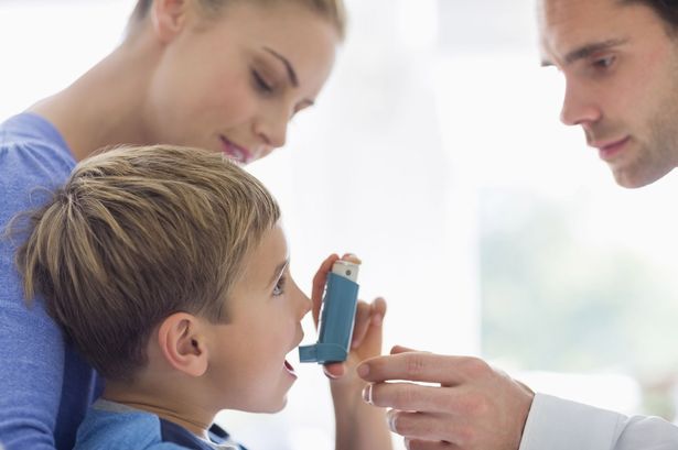 Parents-giving-son-asthma-inhaler