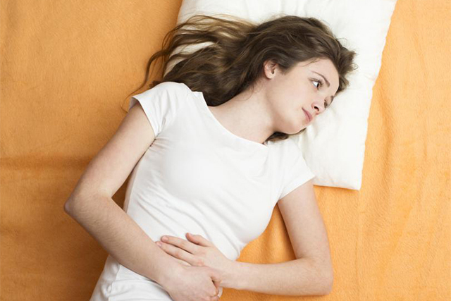 woman-in-white-with-stomach-pain