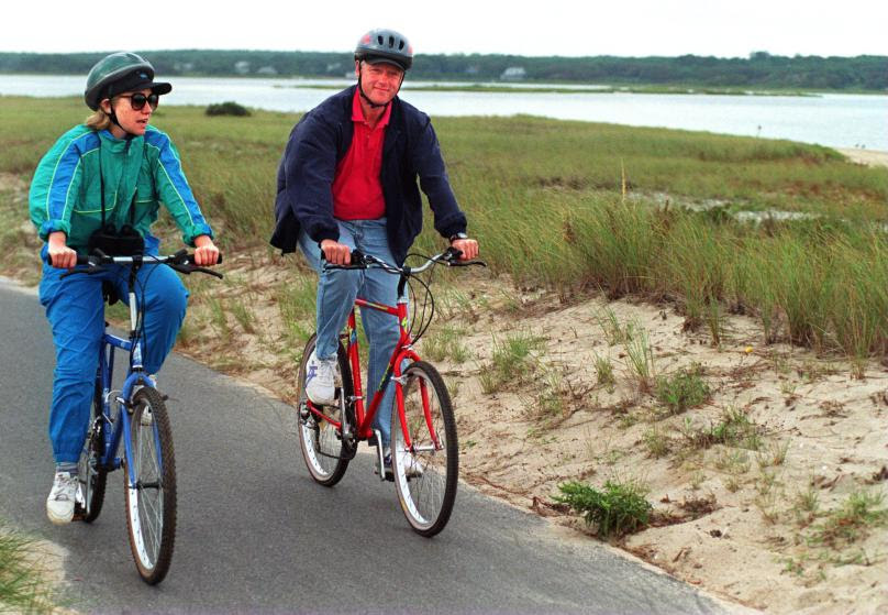 94 MARTHA'S VINEYARD - SEPTEMBER: President Bill Clinton bikes with his wife, Hillary Clinton, during their vacation on Martha's Vineyard. (Photo by Evan Richman/The Boston Globe via Getty Images)