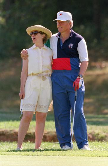 93 MARTHA'S VINEYARD, MA - AUGUST 27:  Massachussets: U.S. President Bill Clinton (R) and First Lady Hillary Clinton give each other a hug while playing golf at the Mink Meadows Golf Club on Martha's Vineyard 27 August 1993 in Massachusetts. The First Family is vacationing on the island.  (Photo credit should read J. DAVID AKE/AFP/Getty Images)
