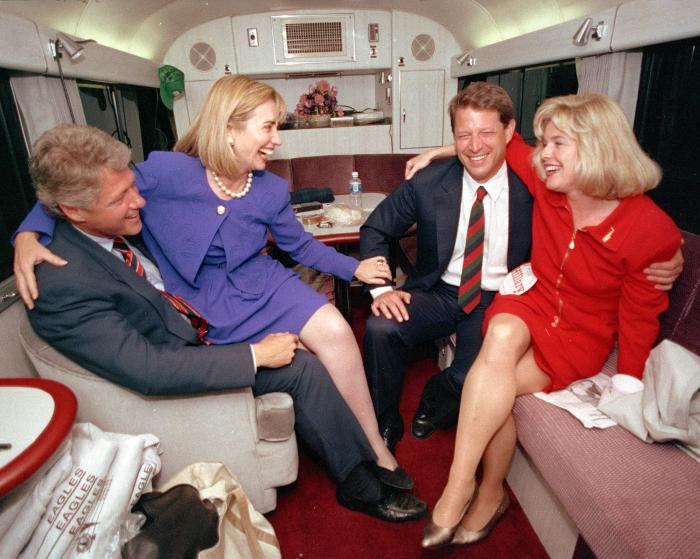 1992 Hillary Rodham Clinton sits on the lap of her husband, democratic presidential candidate Bill Clinton left, as she jokes with vice presidential candidate Al Gore and his wife, Tipper, during a brief rest on their bus in Durham, N.C., Monday, Oct. 26, 1992.  The democratic ticket has spent the last two days touring the state.  (AP Photo/Stephan Savoia)