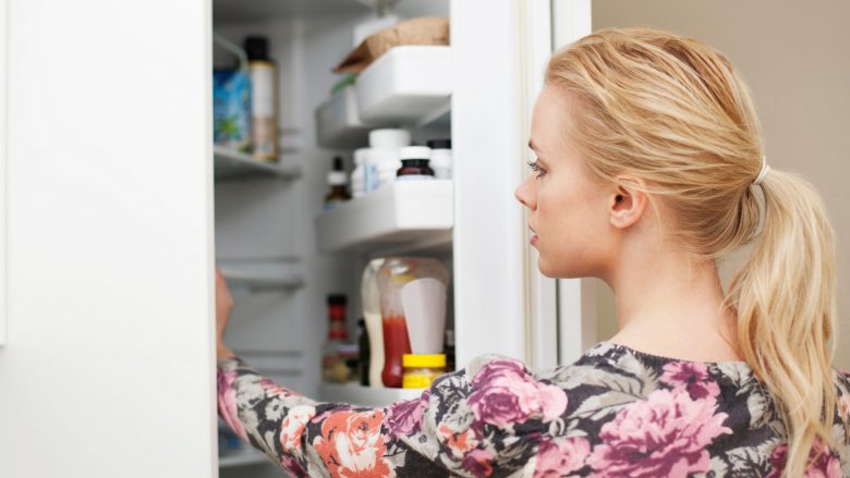 Young woman looking in refrigerator