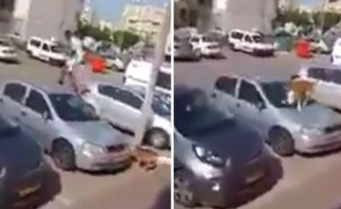 Burri i tmerruar hip mbi vetura, për të shpëtuar kokën nga qeni (Video)