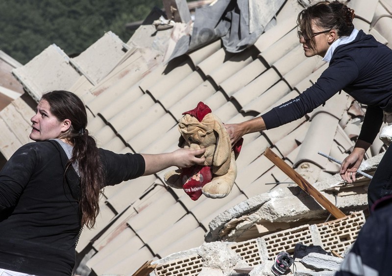 epa05508460 Two woman hold a peluche in Amatrice, central Italy, 24 Augut 2016, following a 6.2 magnitude earthquake, according to the United States Geological Survey (USGS), that struck at around 3:30 am local time (1:30 am GMT). The quake was felt across a broad section of central Italy, in Umbria, Lazio and Marche Regions, including the capital Rome where people in homes in the historic center felt a long swaying followed by aftershocks. According to reports at least 37 people died in the quake. EPA/MASSIMO PERCOSSI