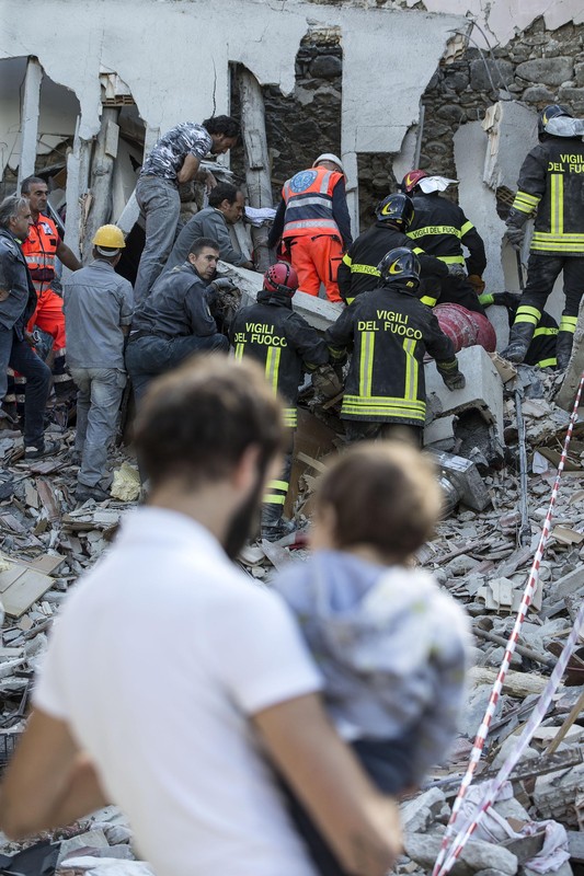 epa05508720 Rescuers of the local fire department work to pull a victim from the rubble of a collapsed building in Fonte del Campo near Accumoli, central Italy, 24 August 2016, following a 6.2 magnitude earthquake, according to the United States Geological Survey (USGS), that struck at around 3:30 am local time (1:30 am GMT). The quake was felt across a broad section of central Italy, in Umbria, Lazio and Marche Regions, including the capital Rome where people in homes in the historic center felt a long swaying followed by aftershocks. According to reports at least 38 people died in the quake. EPA/ANGELO CARCONI