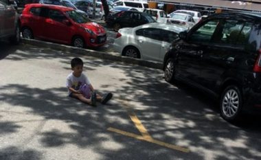 E tmerrshme: Nëna detyron të birin të qëndroj mbi një orë i ulur në asfalt që t’ia ruaj parkingun (Foto)