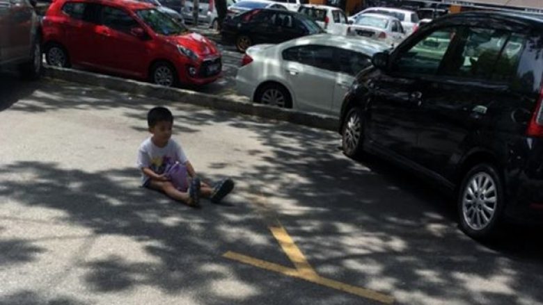 E tmerrshme: Nëna detyron të birin të qëndroj mbi një orë i ulur në asfalt që t’ia ruaj parkingun (Foto)