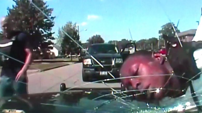 Polici thyen xhamin e veturës me kokën e të riut me ngjyrë që e kishte prangosur (Video)