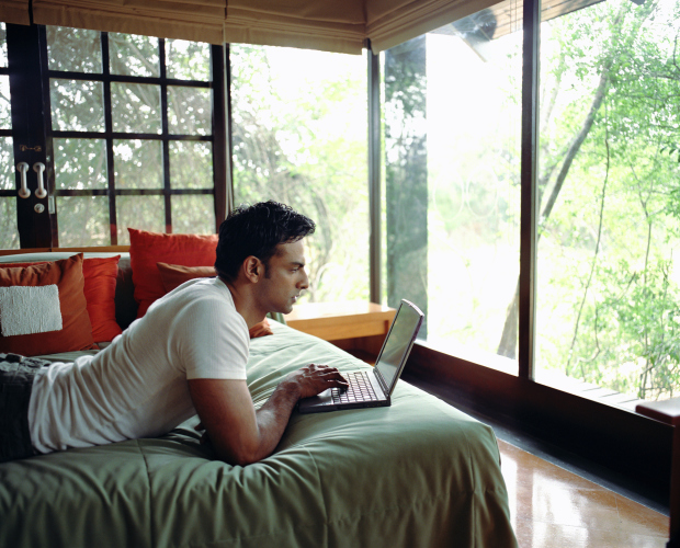 Young man on bed using laptop