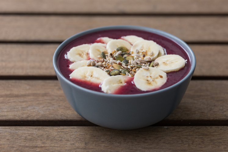 "Acai Bowl - Acai berry smoothie topped with banana and 'Omega' seeds, a healthy breakfast."