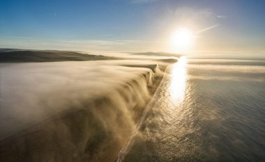 Droni filmon momentin kur mjegulla bie si ‘ujëvarë’ nga shkëmbi (Video)
