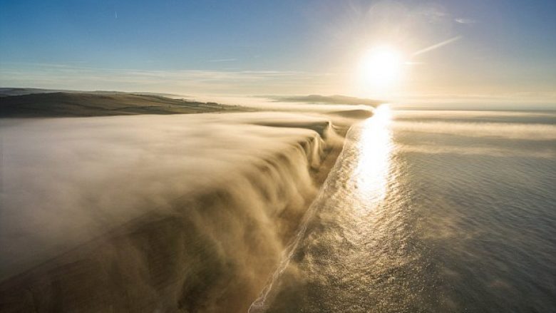 Droni filmon momentin kur mjegulla bie si ‘ujëvarë’ nga shkëmbi (Video)