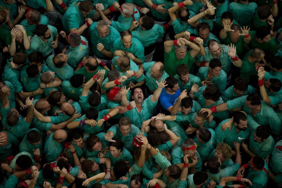 Members of the "Castellers de Villafranca" react after completing their human tower during the 26th Human Tower Competition in Tarragona, Spain, on Sunday, Oct. 2, 2016. The tradition of building human towers, or Castells, dates back to the 18th century and takes place during festivals in Catalonia, where colles, or teams, compete to build the tallest and most complicated towers. The structure of the castells varies depending on their complexity. A castell is considered completely successful when it is loaded and unloaded without falling apart. The highest castell in history was a 10 floor structure with 3 people in each floor. In 2010 castells were declared by UNESCO one of the Masterpieces of the Oral and Intangible Heritage of Humanity. (AP Photo/Emilio Morenatti)