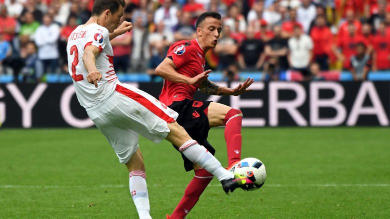 Switzerland's Stephan Lichtsteiner, left, goes for the ball with Albania's Ergys Kace during the Euro 2016 Group A soccer match between Albania and Switzerland, at the Bollaert stadium in Lens, France, Saturday, June 11, 2016. (AP Photo/Geert Vanden Wijngaert)
