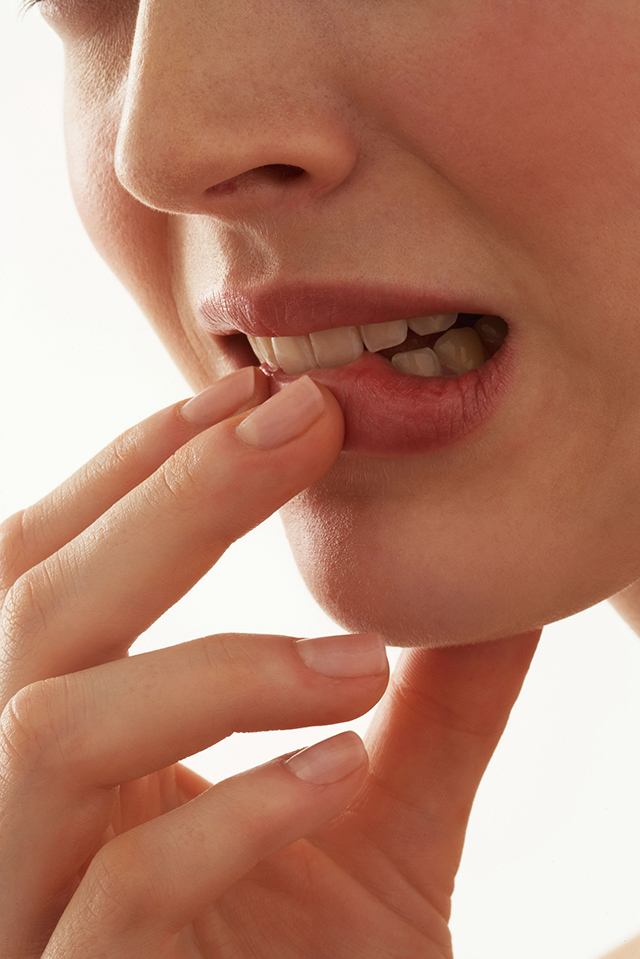 Young woman biting lip, close-up