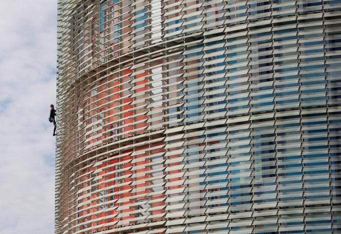 French climber Alain Robert, also known as "The French Spiderman", scales the 38-story skyscraper Torre Agbar in Barcelona