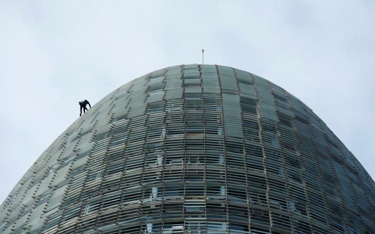 French climber Alain Robert, also known as "The French Spiderman", scales the 38-story skyscraper Torre Agbar in Barcelona