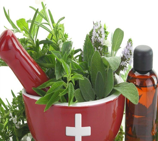 Mortar with medicine cross, fresh herbs and essential oil bottle