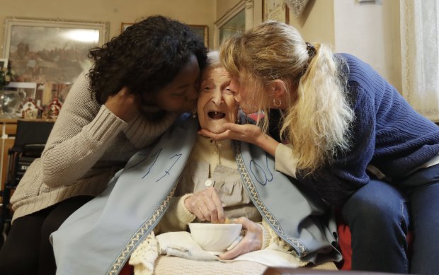 Emma Morano, 117 years hold, is kissed by her caretakers Malgorzat Ceglinska, right, and Yamilec Vergara, in the day of her birthday in Verbania, Italy, Tuesday, Nov. 29, 2016. At 117 years of age, Emma is now the oldest person in the world and is believed to be the last surviving person in the world who was born in the 1800s, coming into the world on Nov. 29, 1899. (AP Photo/Antonio Calanni)