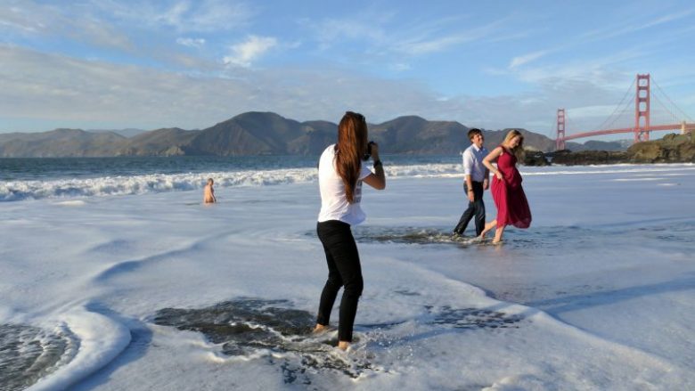 Gjatë fotosesionit në bregdet, u befasuan nga një burrë që doli i zhveshur nga uji (Foto)