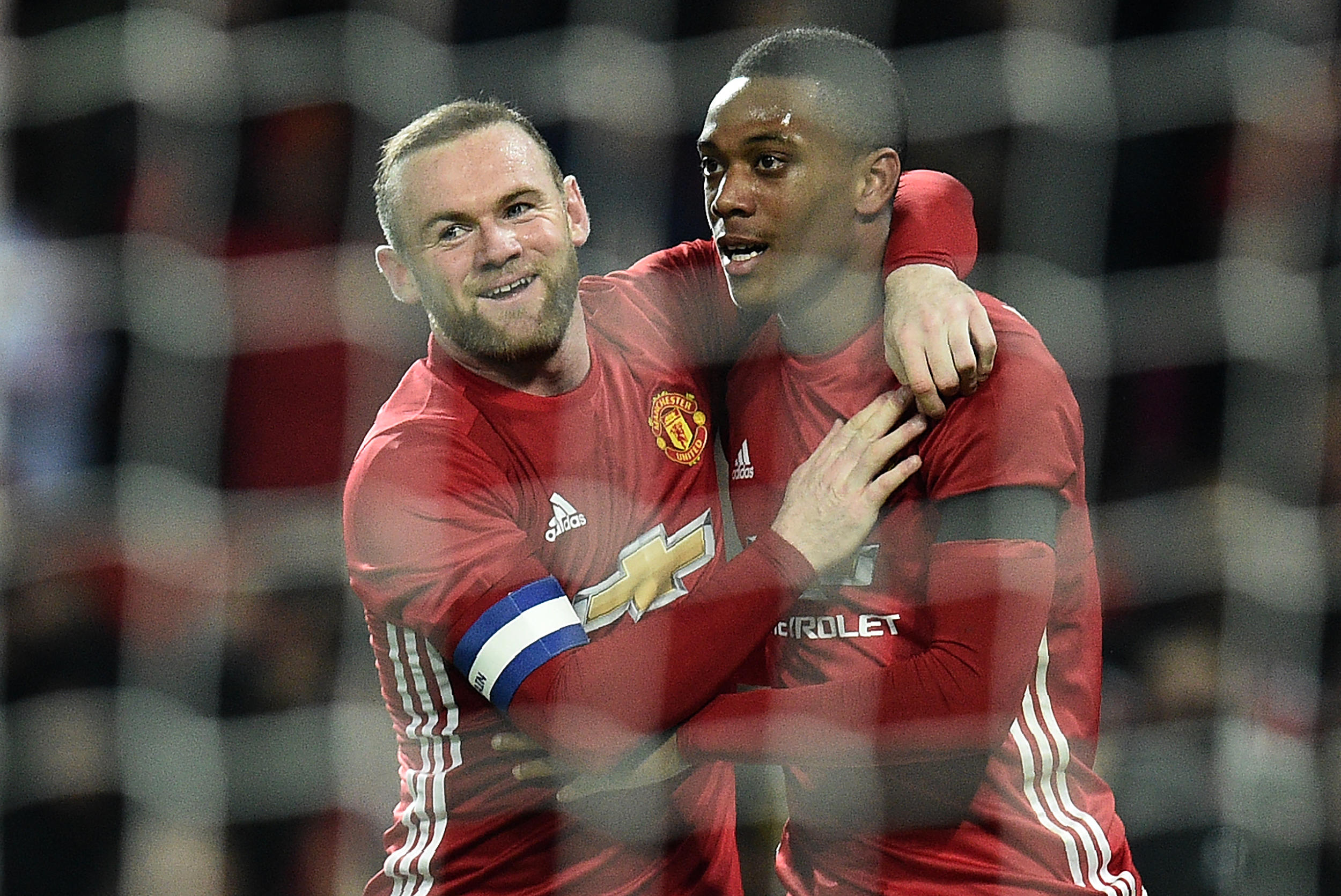 Manchester United's French striker Anthony Martial (R) celebrates scoring his team's third goal with Manchester United's English striker Wayne Rooney during the EFL (English Football League) Cup quarter-final football match between Manchester United and West Ham United at Old Trafford in Manchester, north west England, on November 30, 2016. / AFP / Oli SCARFF / RESTRICTED TO EDITORIAL USE. No use with unauthorized audio, video, data, fixture lists, club/league logos or 'live' services. Online in-match use limited to 75 images, no video emulation. No use in betting, games or single club/league/player publications. / (Photo credit should read OLI SCARFF/AFP/Getty Images)