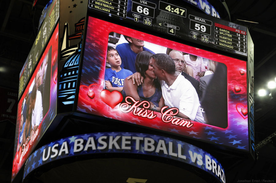 U.S. President Barack Obama and first lady Michelle Obama are shown kissing on the "Kiss Cam" screen during a timeout in the Olympic basketball exhibition game between the U.S. and Brazil national men's teams in Washington, July 16, 2012. REUTERS/Jonathan Ernst (UNITED STATES - Tags: POLITICS SPORT BASKETBALL OLYMPICS)