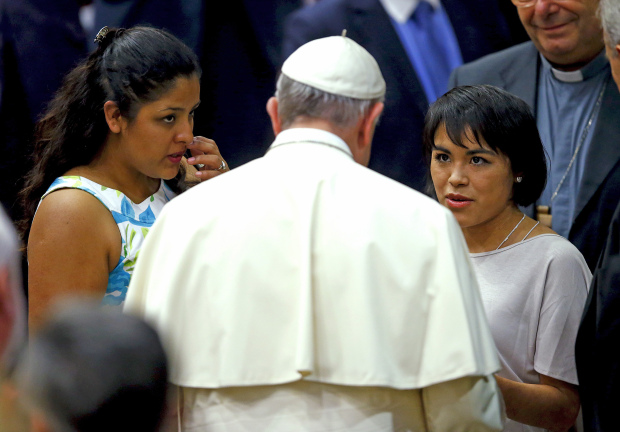 Pope Francis talks with victims of forced labor Anna Laura Perez Jaimes (R) and Karla Jacinto during the "Modern Slavery and Climate Change" conference at the Vatican July 21, 2015. Pope Francis on Tuesday urged the United Nations to take a "very strong stand" on climate change at a landmark summit this year in Paris on global warming. The pope spoke at a Vatican-hosted conference of mayors and governors from major world cities who signed a declaration urging global leaders to take bold action at the U.N. summit, saying it may be the last chance to tackle human-induced global warming. REUTERS/Tony Gentile - RTX1L923