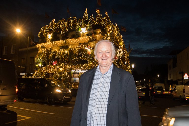Landlord Gerry O'Brien, 65, outside of The Churchill Arms, London. 07 December 2016. The tree is decorated with 85 trees and 20,000 lights which took a week and a half to put in place. The famous pub, near to Notting Hill Gate, has useflowers and plants all year round attract punters for nearly 30 years.