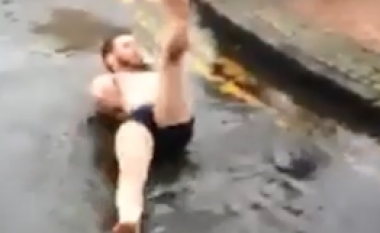 Zhvishet në mot të ftohtë dhe noton në ujin e pellgut të rrugës (Video)
