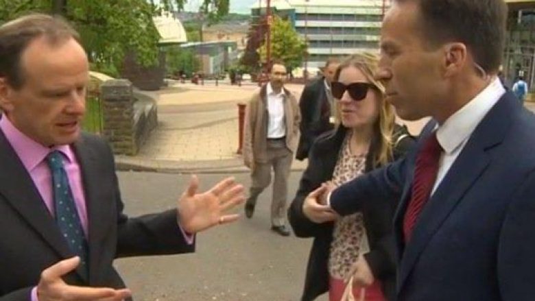 Gazetari i BBC-së ia prekë aksidentalisht gjoksin kalimtares, derisa ishte në transmetim të drejtpërdrejt (Video)